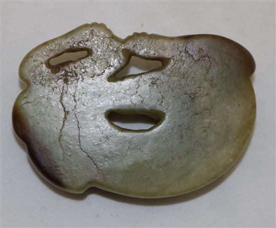 A Chinese greenish-yellow and brown jade carving of a recumbent hound, possibly Ming dynasty, 6.7cm